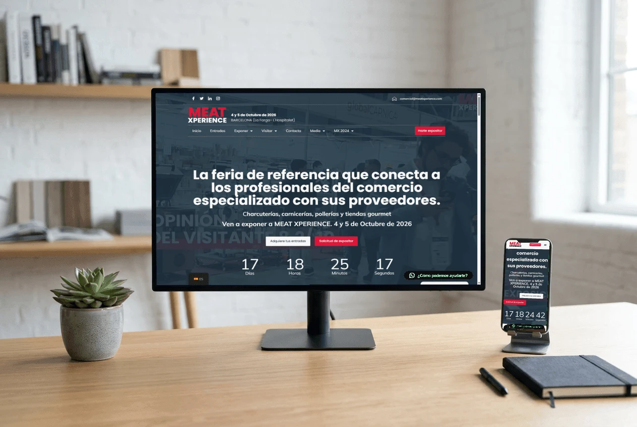 La portada de meatxperience.com en un monitor de escritorio y su versión móvil en un teléfono sobre la mesa.
