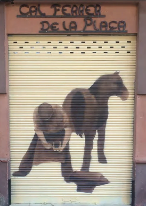 Persiana metálica de una tienda pintada con la silueta de un caballo.